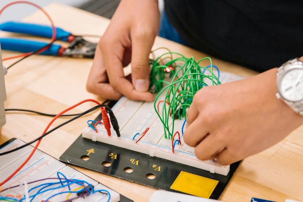 a person connecting jumper wires on a breadboard